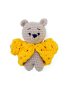 Miniature handmade beige crochet teddy bear wearing a bright yellow textured sweater.