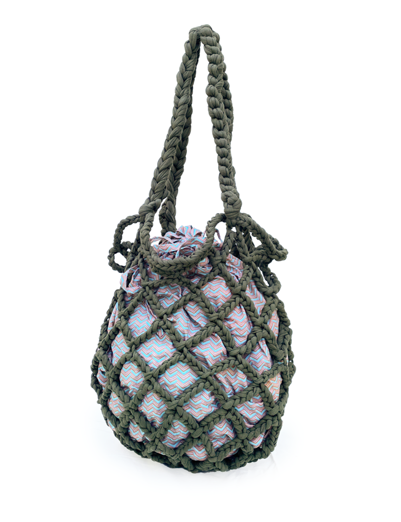 Dark olive green mesh crochet bag with braided handles and a patterned fabric inner sack.