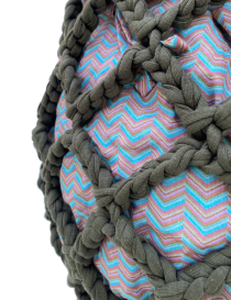 Dark olive green mesh crochet bag with braided handles and a patterned fabric inner sack.