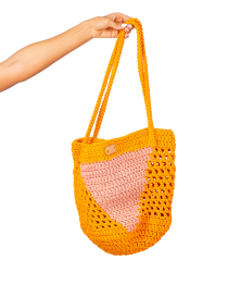 Yellow and pink crochet mesh beach bag with triangle pattern.