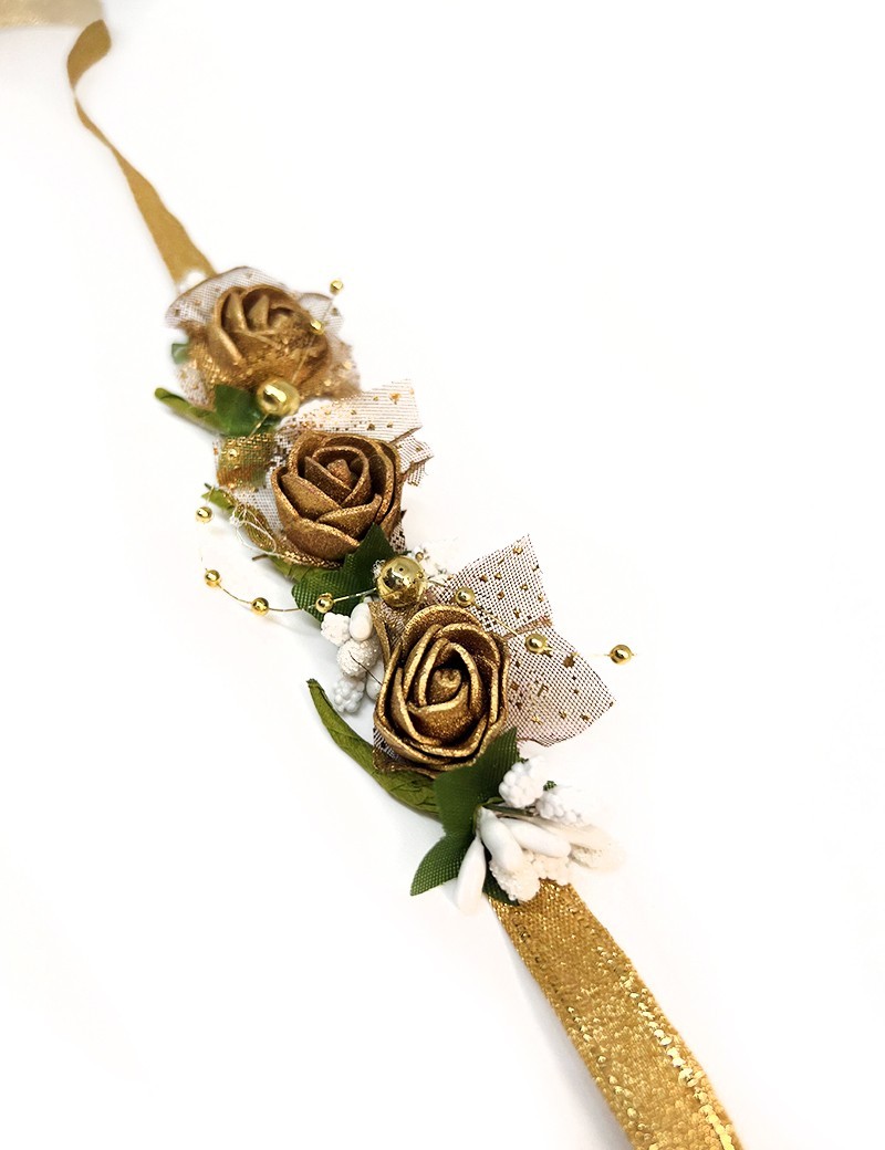 Golden fabric rose wreath accessory with white berries on a gold ribbon.