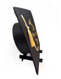 Graduation cap topper with gold Arabic calligraphy and colorful floral embroidery.