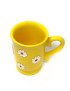Hand-painted yellow ceramic mug with white daisy floral design and decorative handle.