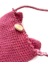 Close-up of wooden button closure on a pink handmade crochet bag.