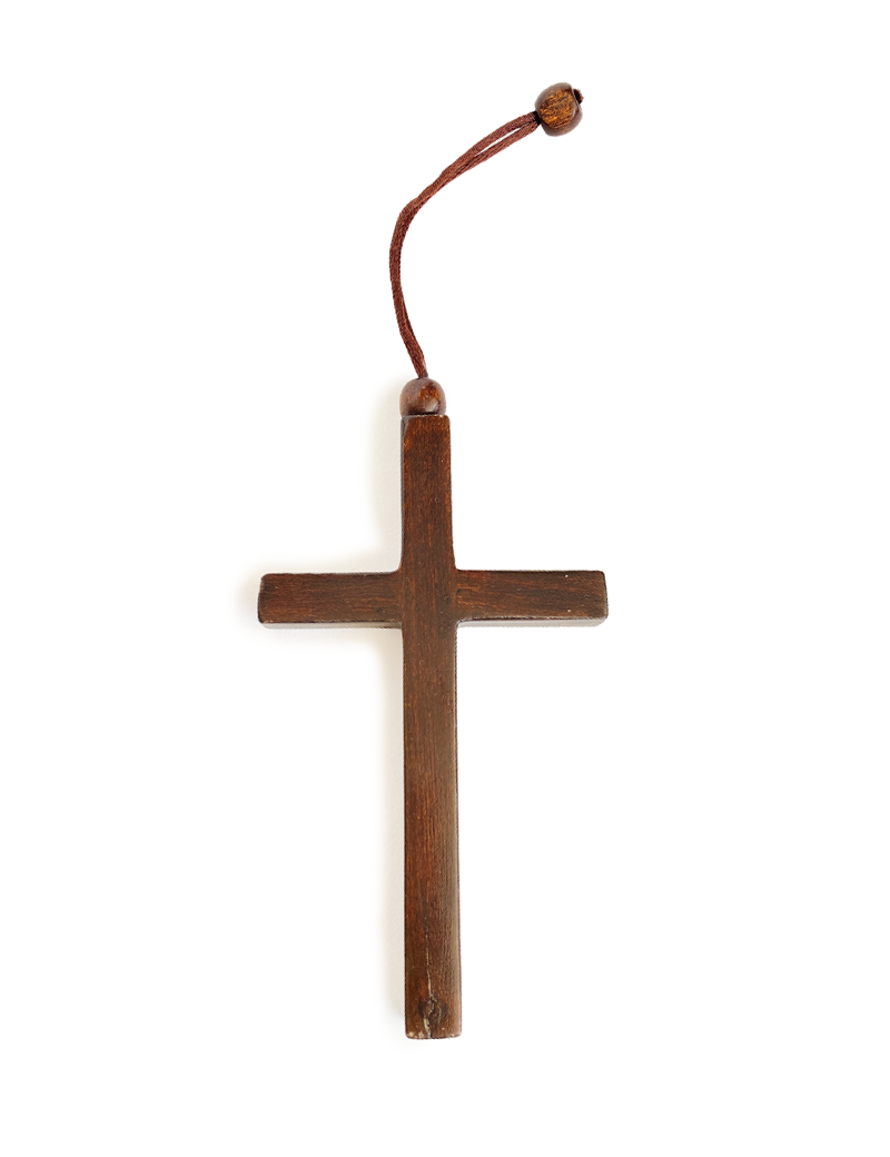 Top-down view of a minimalist wooden cross with a hanging cord and bead.
