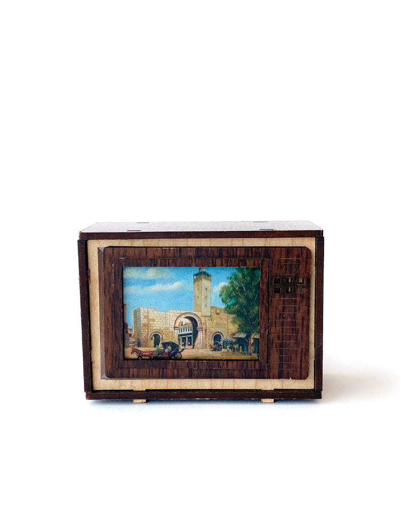 Front view of wooden miniature TV showing traditional city gate.
