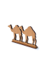 Minimalist handcrafted wooden camel trio silhouette on base.