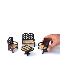 Hand showing scale of small laser-cut wooden furniture set.