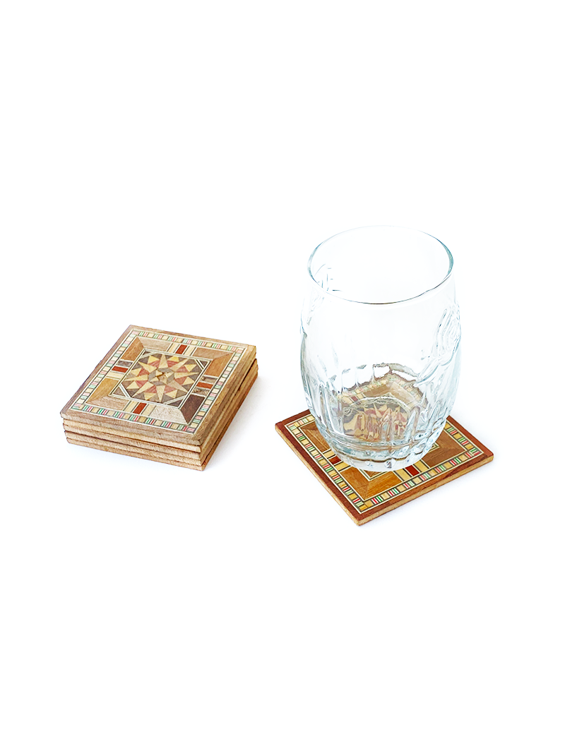 Mosaic wood coaster in use under a clear glass on a white background.