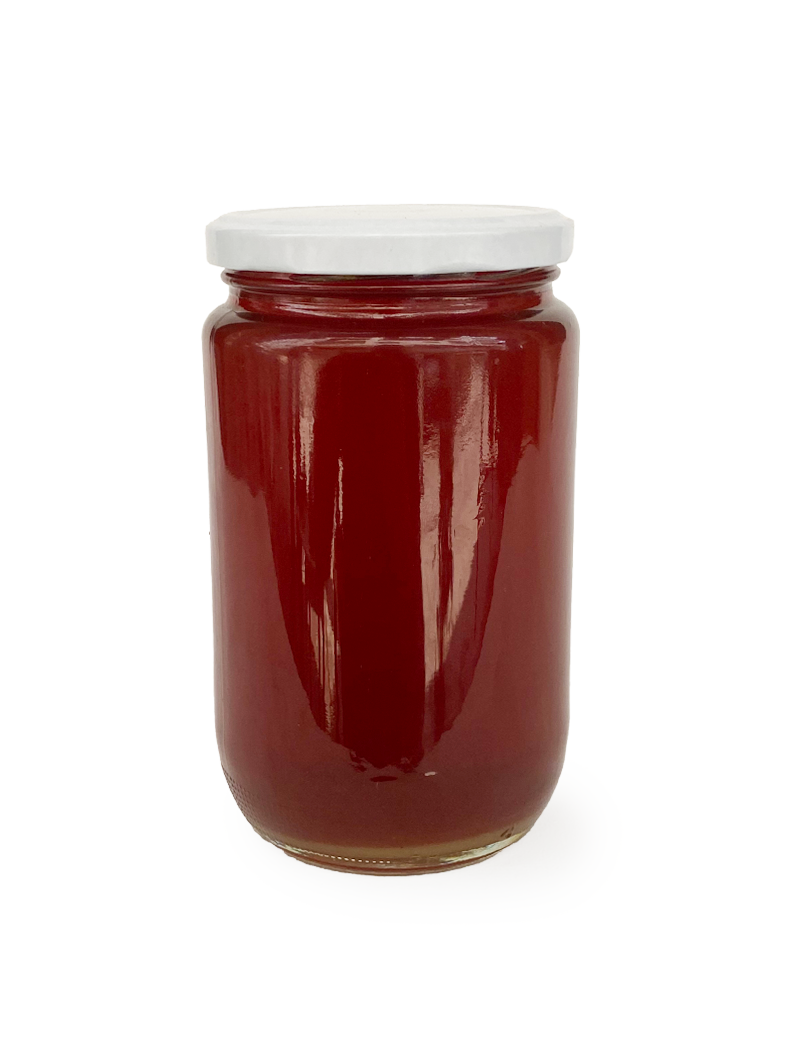 A glass jar of authentic dark amber Syrian Mountain Honey with a white lid.