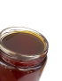 Close-up of the smooth, rich texture of raw Syrian honey inside a glass jar.