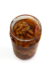 Close-up of raw honey with whole walnuts and almonds.