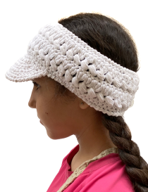 Side profile of a young woman wearing a white handmade crochet sun visor.