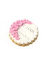 Custom name sugar cookie with "Carol Georg" and pink floral icing border.