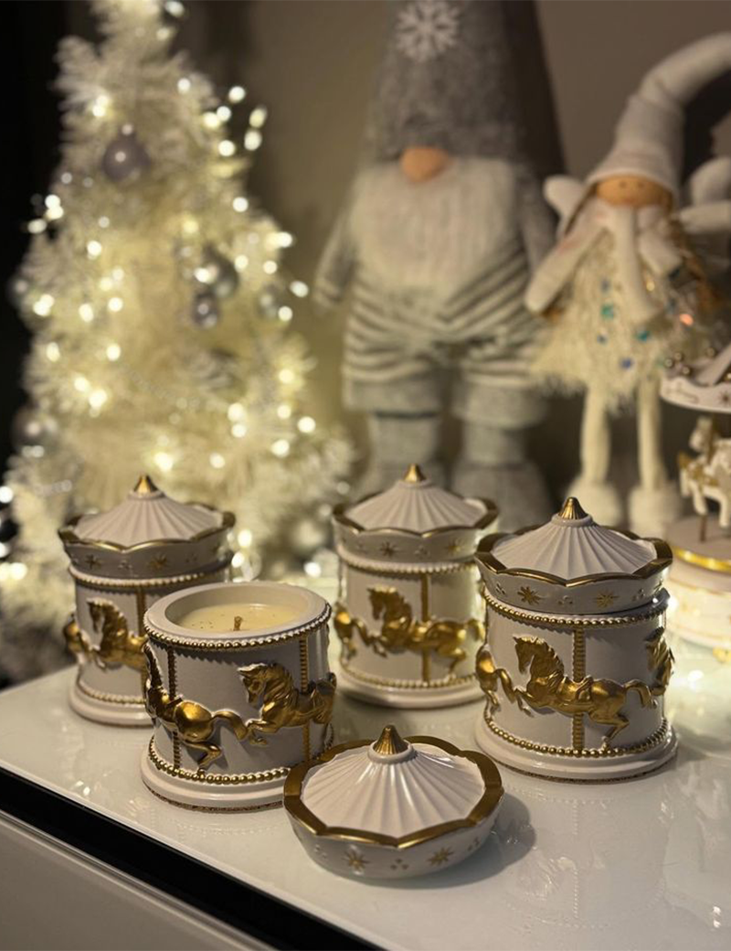 Collection of white and gold concrete carousel candles in a festive holiday setting.