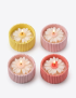 Close-up of 5cm concrete candle jars with intricate daisy flower wax designs.