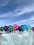 Colorful handcrafted floral candles on stems with glitter centers by Tabark Designs.