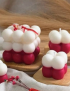 Custom red and white layered bubble candles on wooden trays.