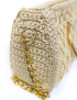 Close-up side details of handmade luxury purse with detachable gold chain attachment.