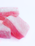 Close-up shot of soft and chewy pink saffron loukoum delights dusted with fine sugar.