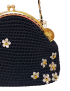 Detailed view of white jasmine embroidery with gold beads on black macramé thread