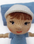 Close-up of Nano doll smiling face with open eyes lying on a small soft blue pillow