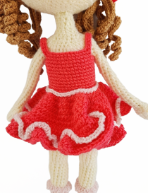 Close-up of ruffled pink crochet dress and matching shoes on handmade doll