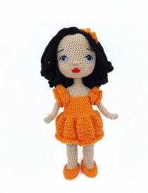 Full standing view of Lora handmade crochet doll in bright orange dress