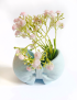 Light blue bow-shaped gypsum decorative vase by Night Candles filled with small white flowers for home decor delivery in Syria