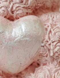 Macro detail of the shimmering silver heart held by the handmade bear