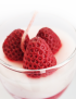 Top view of strawberry cheesecake scented candle with wax strawberries in a goblet glass