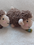 A pair of handmade crochet sheep toys by Saja Handmade, in brown and cream plush velvet yarn, on a soft white rug.