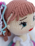 Detailed view of handcrafted doll face with curly hair and blue eyes
