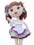 Celina handcrafted crochet doll posing in colorful ruffle dress