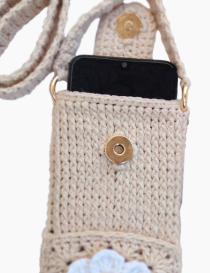 Close-up of smartphone inside crochet bag with gold magnetic snap