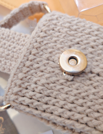 Detail view of gold magnetic lock and cotton yarn stitch