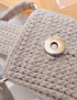 Detail view of gold magnetic lock and cotton yarn stitch