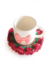 Handmade red rose crochet coaster holding a mug with a bow pattern.