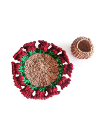 Top-down view of hand-knitted rose coaster and woven yarn holder ring.