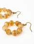 Macro shot of striped glass beads in orange and beige with gold-tone spacers.
