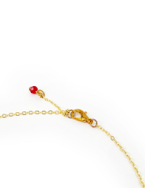 lose-up of gold lobster clasp and red bead charm extension on necklace.