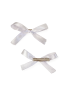 Detail view of a white satin bow clip showing the alligator grip.