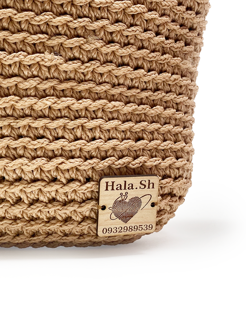 Wooden Hala.Sh brand tag stitched to the crochet exterior.