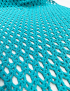 Detailed view of the turquoise open-mesh crochet stitch pattern.