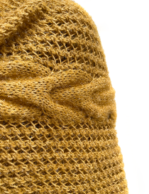 Close-up of golden open-mesh knit and cable-knit pattern.