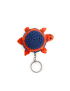Top view of a navy blue crochet turtle keychain with orange shell accents.