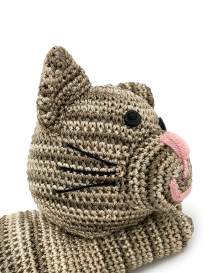 Close-up of crochet cat face showing pink embroidered nose and black button eyes.