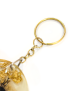 Close-up of a gold-tone metal keychain ring and chain attached to a resin pendant.