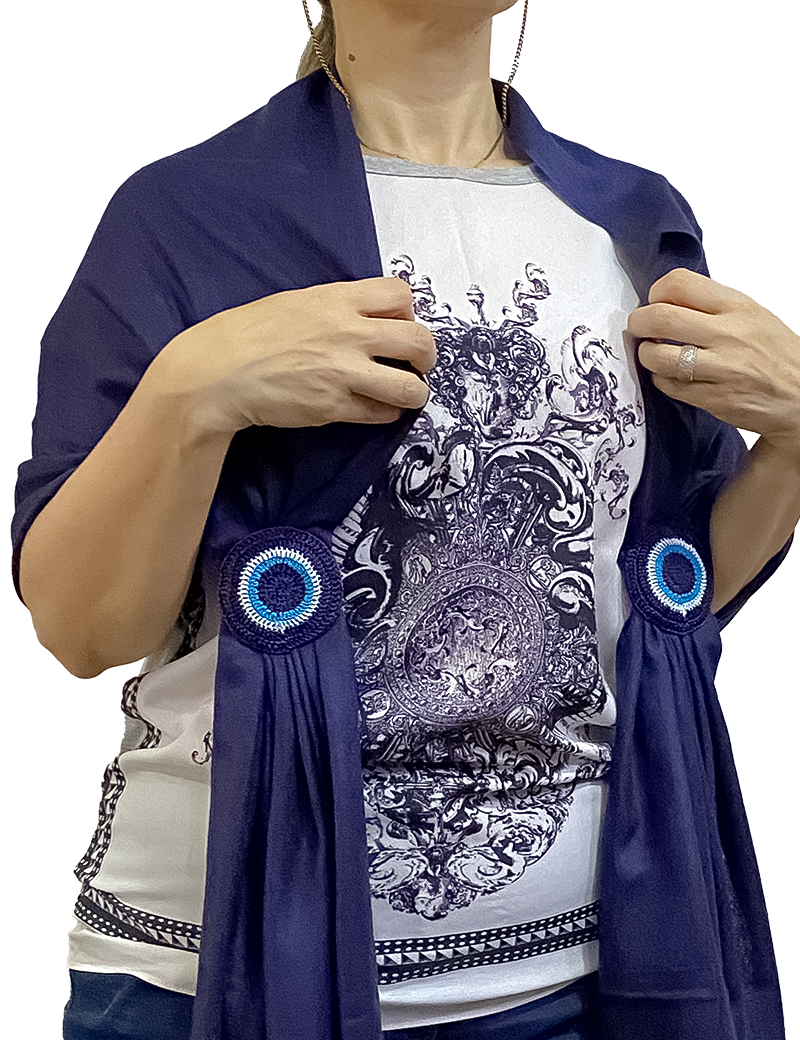 Woman wearing navy blue pashmina shawl showing hand-crocheted blue eye detail.