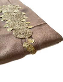 Close-up of metallic coin accents dangling from the handcrafted crochet circles.